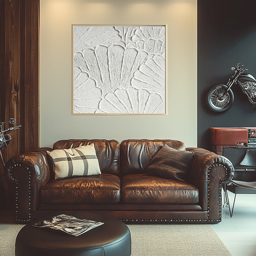 White plaster art texture painting above a chair in a styled room.