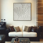 White plaster art texture painting above a white sofa in a living room.