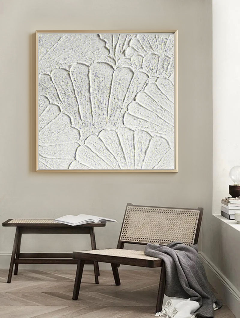 Close-up of white plaster art texture painting above a chair in a room.