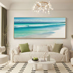 Coastal beach art in a gold frame above a modern sofa.