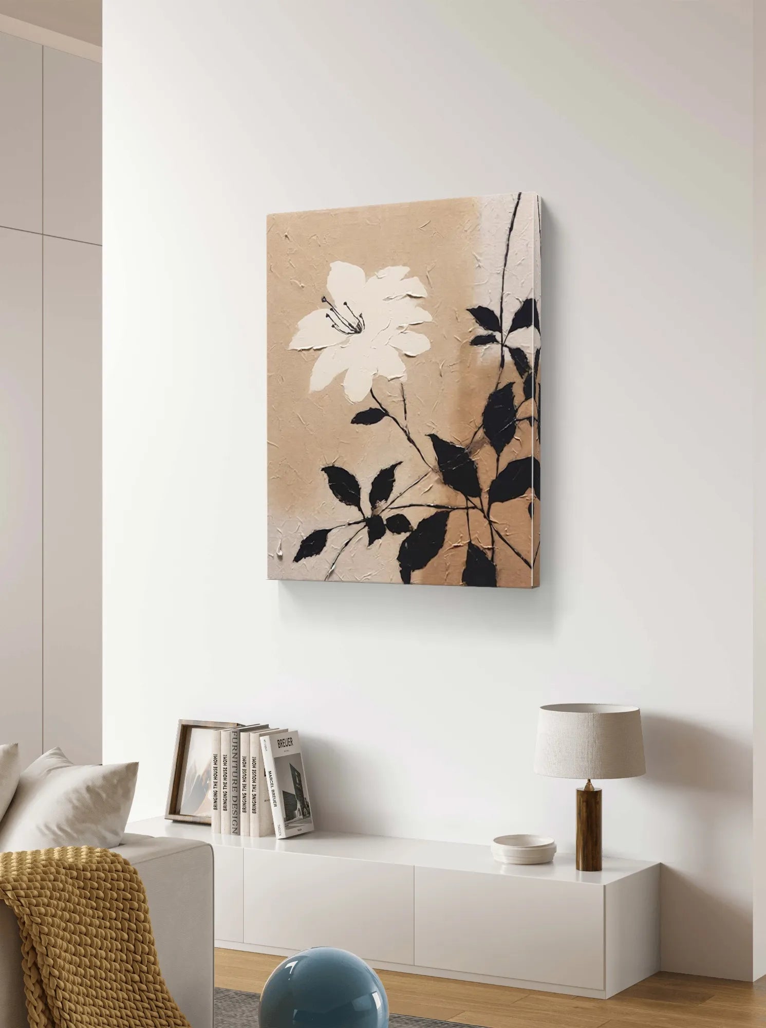 Textured beige floral wall art with a white flower and black leaves on canvas