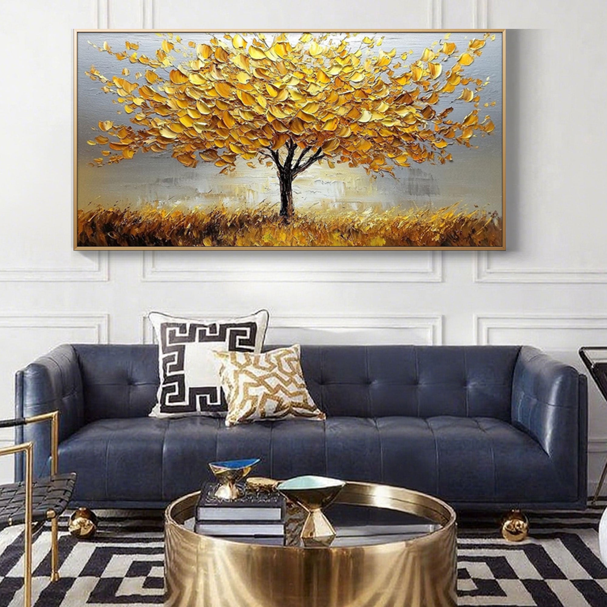 Gold abstract tree painting above blue sofa.