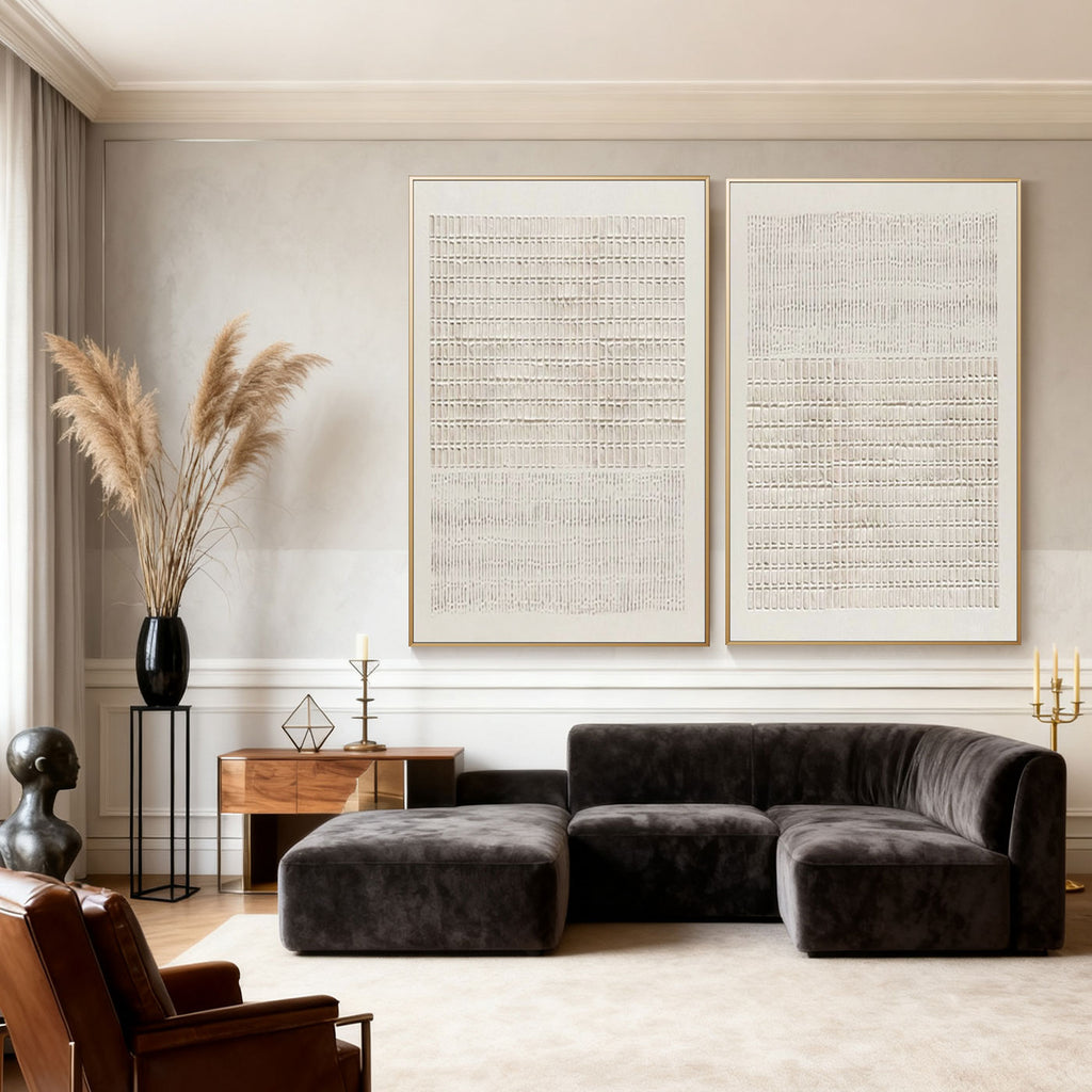 Two minimalist Japandi geometric hand-painted canvas artworks with woven patterns hang above dark gray sectional sofa in modern living room