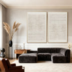 Two minimalist Japandi geometric hand-painted canvas artworks with woven patterns hang above dark gray sectional sofa in modern living room