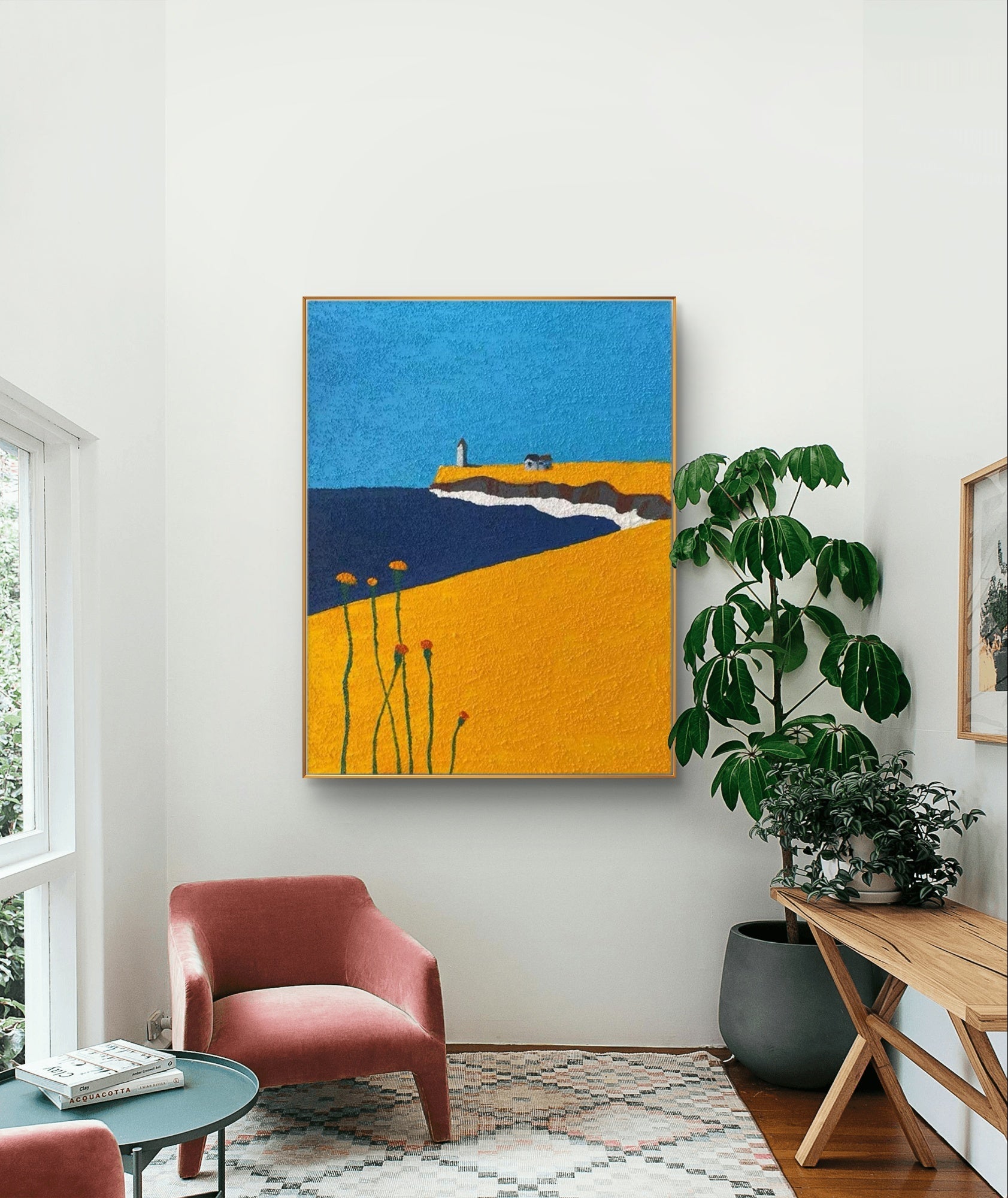 Coastal art with lighthouse, blue sky and yellow field in living room setting.