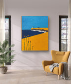 Colorful coastal painting displayed in a living room with yellow armchair.