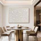 Minimalist beige wall art above a round dining table in a cream-toned room.