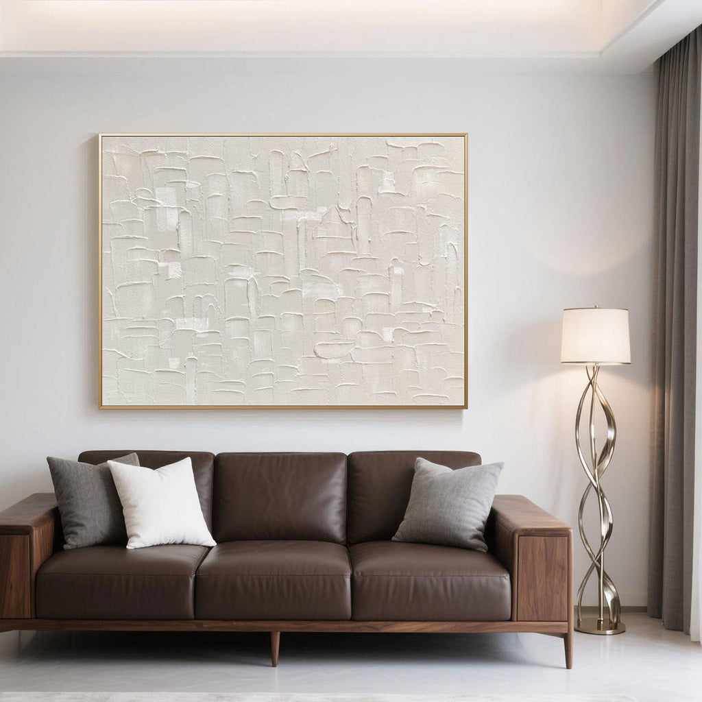 Minimalist art accenting a brown leather couch in a bright, modern room.