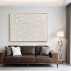 Minimalist art accenting a brown leather couch in a bright, modern room.