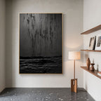 Black textured Wabi Sabi art with gold frame in a stylish interior setting.