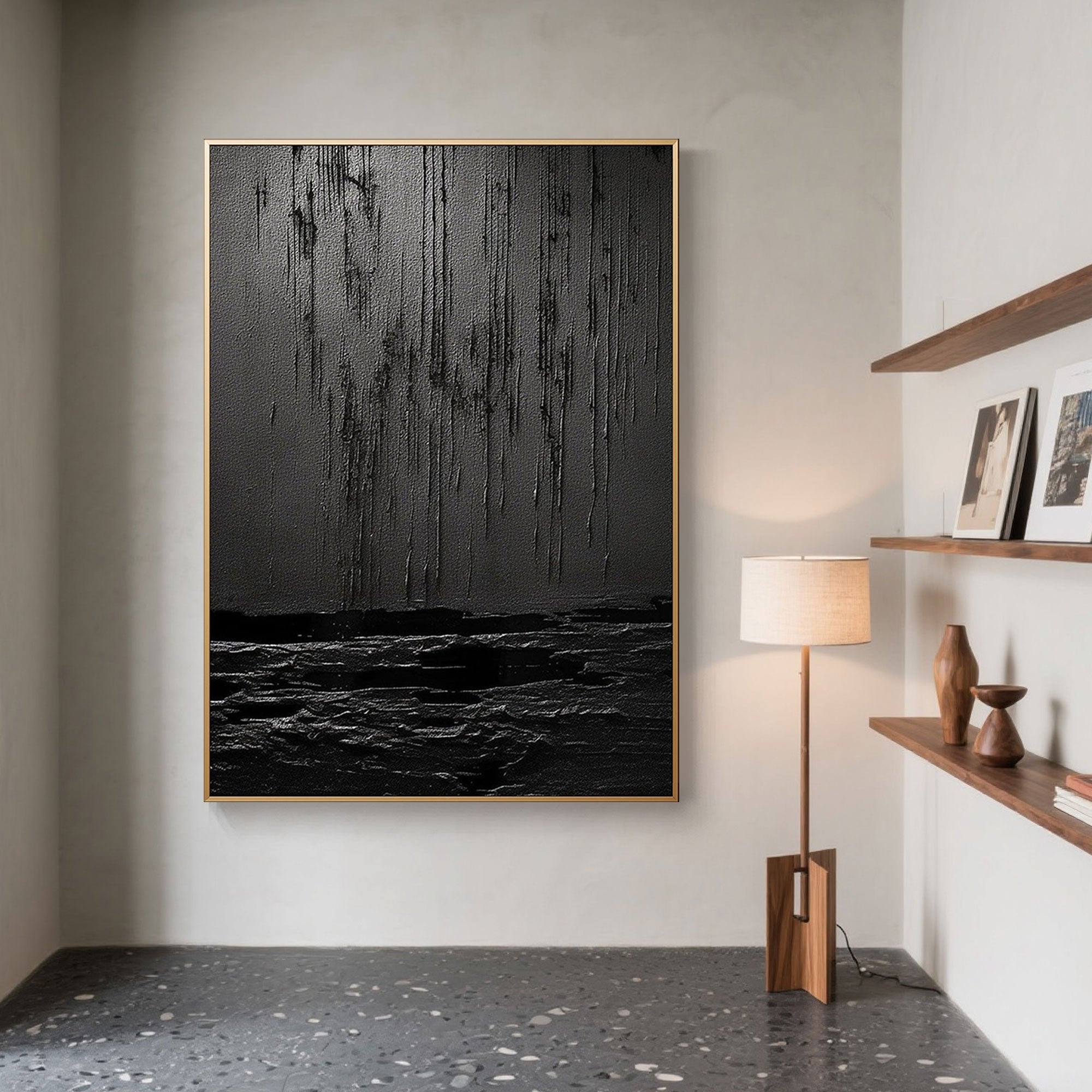 Black textured Wabi Sabi art with gold frame in a stylish interior setting.