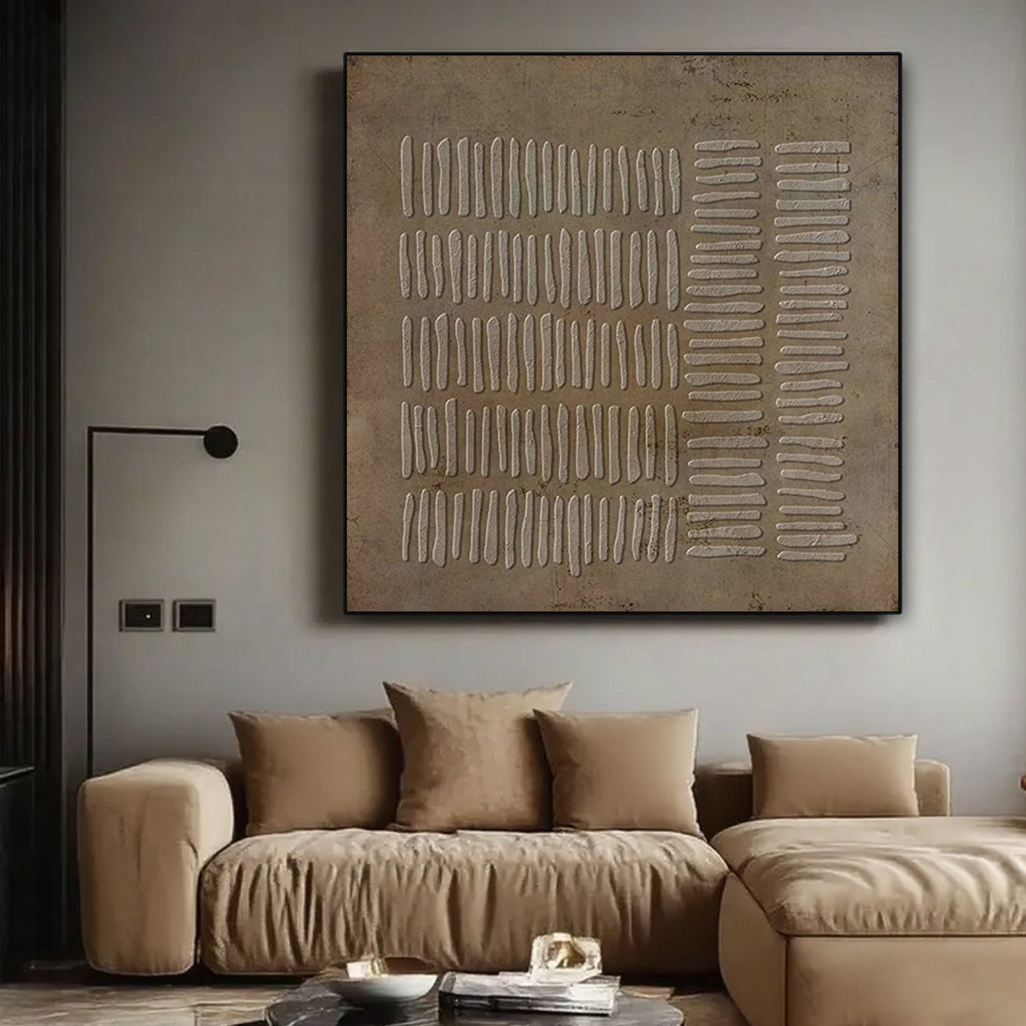 Wabi Sabi brown canvas art displayed above a beige sofa in a living room.