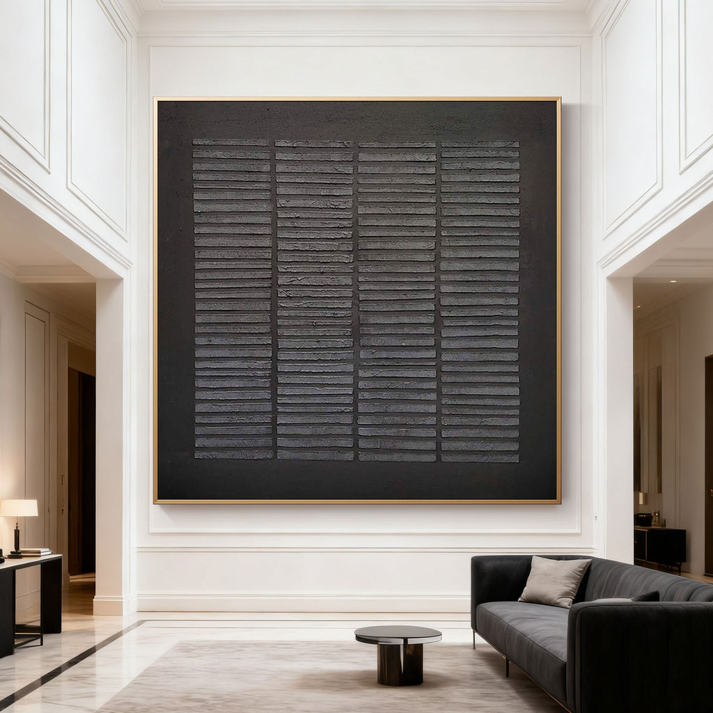 Hand-painted black geometric textured canvas with weathered grid, gold frame in modern living room at Lumi Gallery