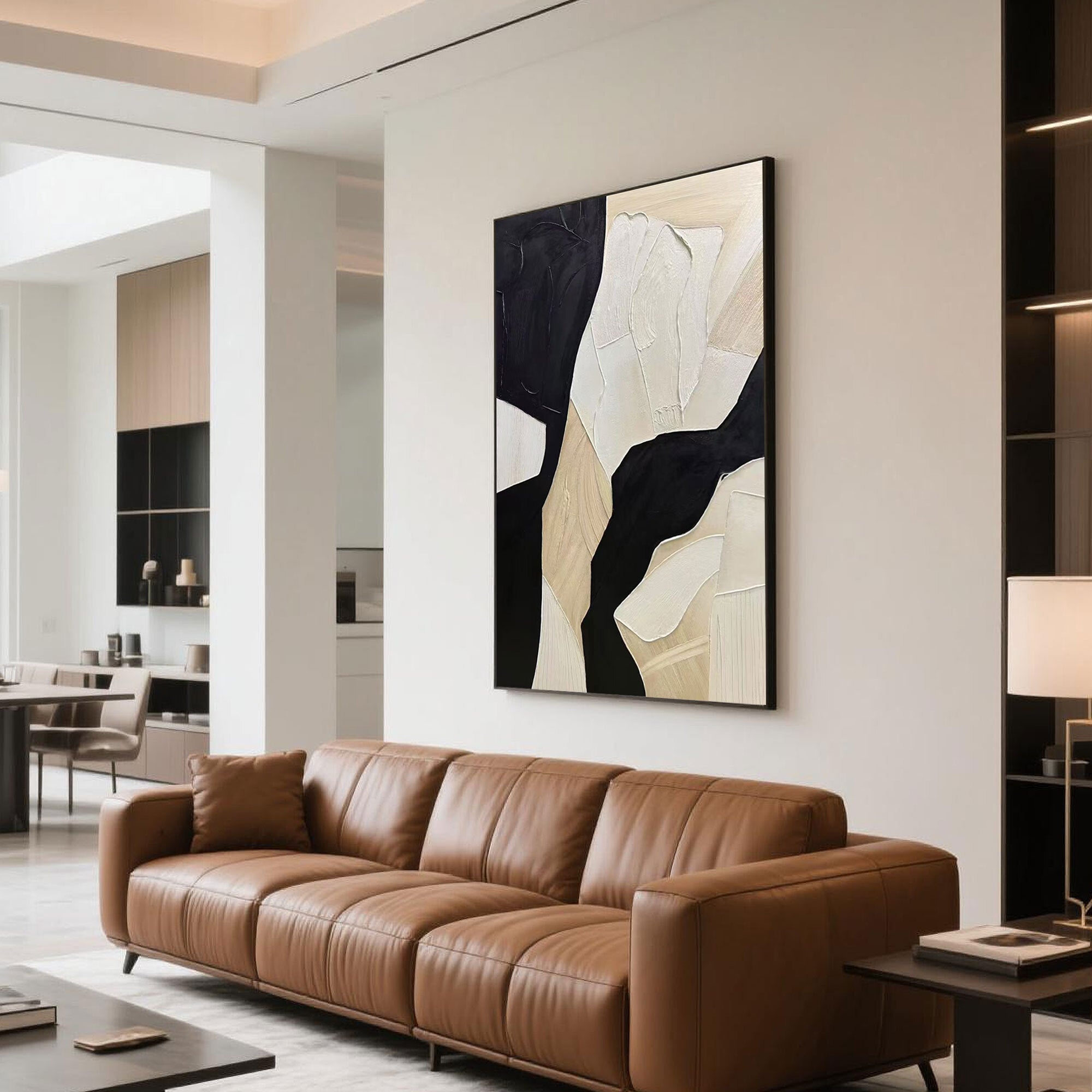 Modern abstract geometric canvas art displayed above a tan leather sofa in a sleek apartment living room with warm lighting.