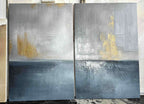Studio view of two textured abstract seascape canvases in blue gray and gold