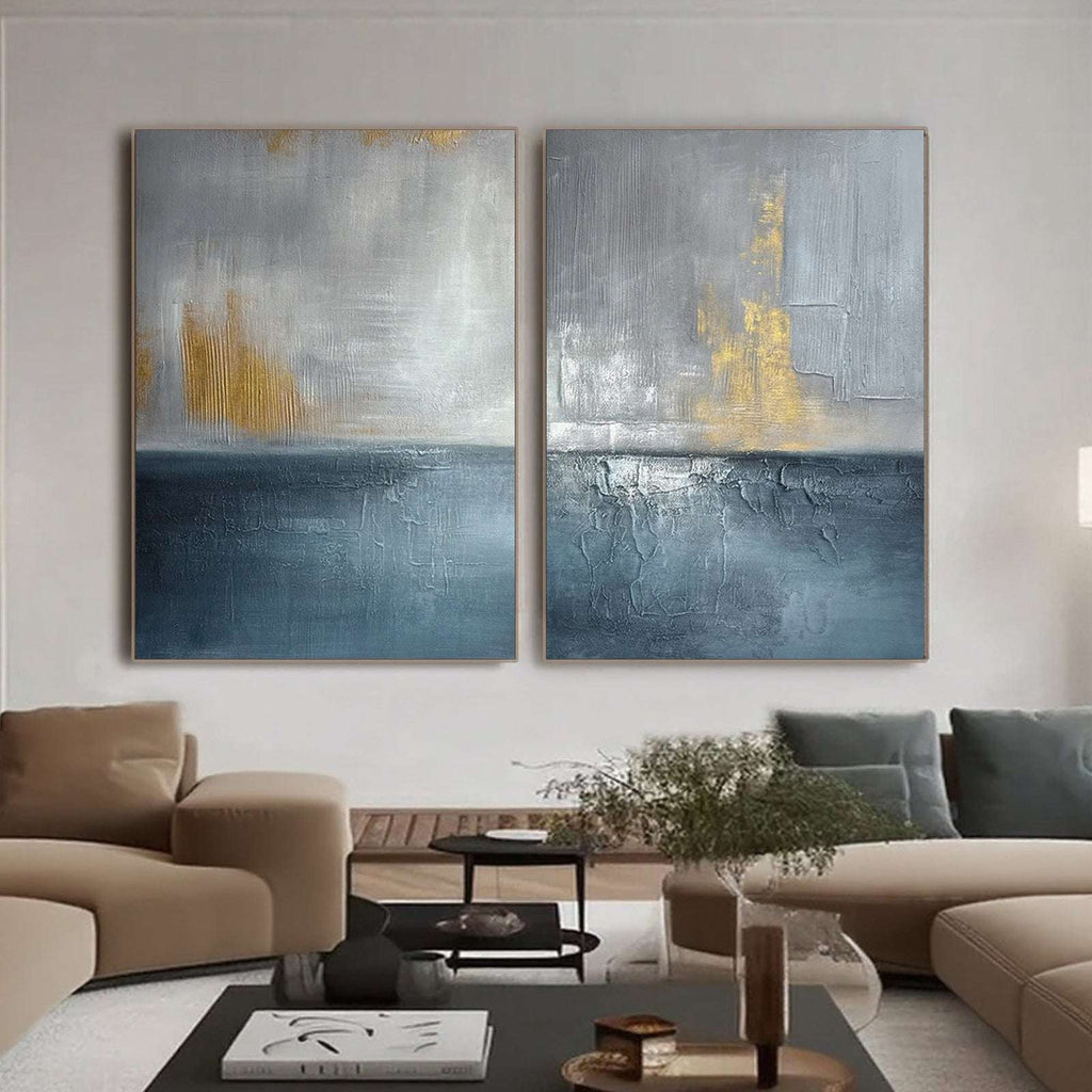 Blue and gold abstract seascape diptych above a sofa in a contemporary living room