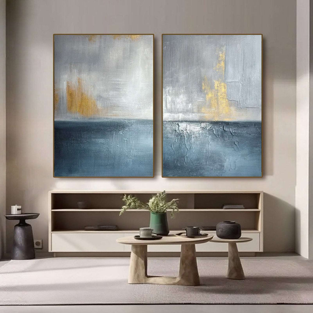 Large vertical blue gold seascape wall art set displayed in a modern living room