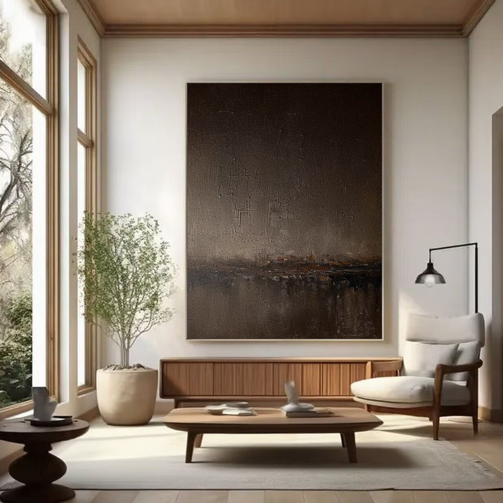 Abstract minimalist brown landscape painting 'Umber Dusk' with textured brushstrokes in umber and dark brown tones, displayed in a modern living room setting.