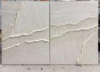 Close-up of white textured wall art with soft raised tide lines across two panels