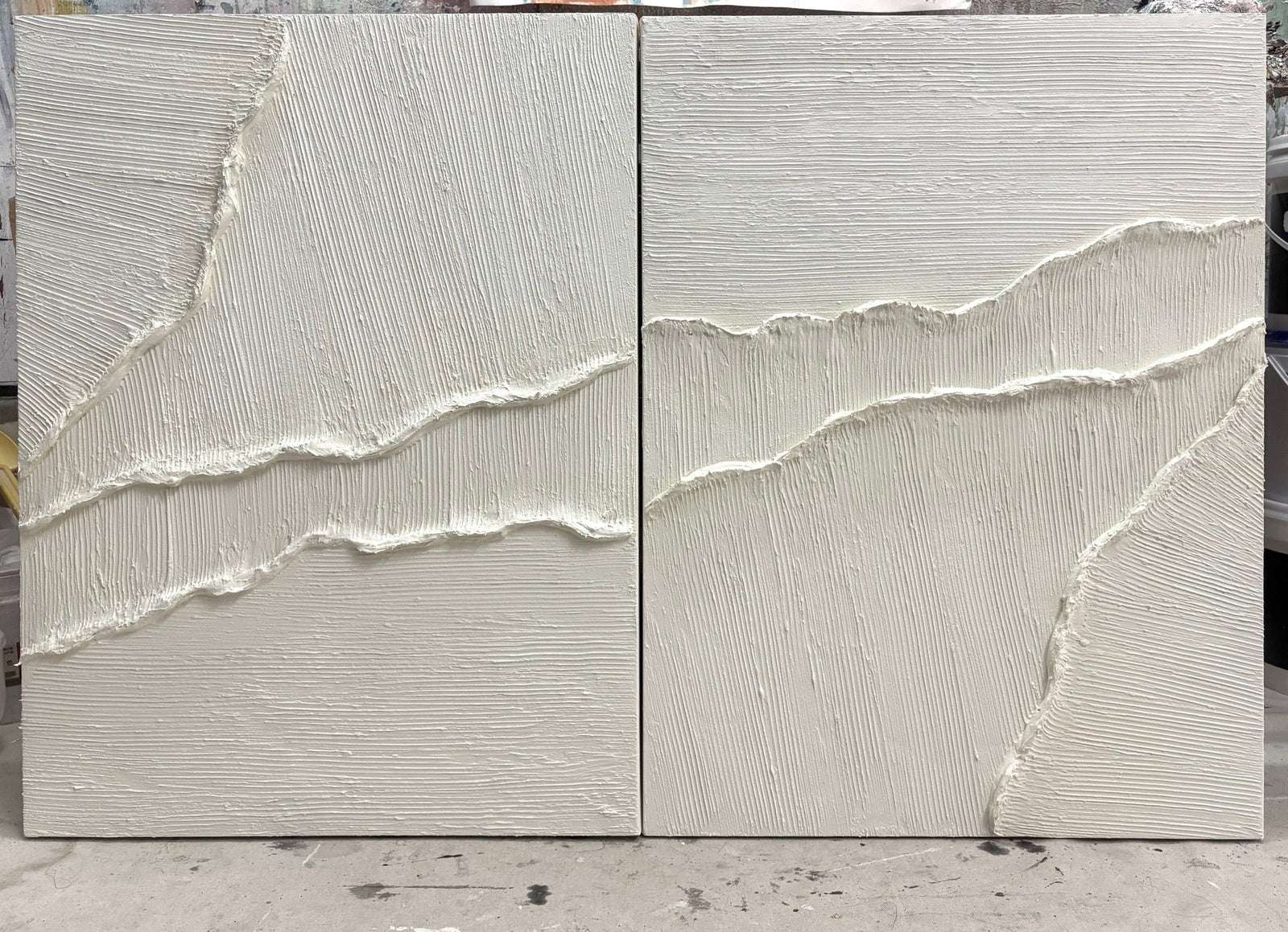 Close-up of white textured wall art with soft raised tide lines across two panels