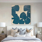 Teal and beige abstract painting above a bed in a styled bedroom.
