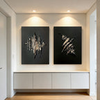 3D Textured Black and Gold Abstract Wall Art 'Fracture & Flame' - Two large canvases with raised gold and black abstract designs mounted on a white wall above a modern white cabinet.