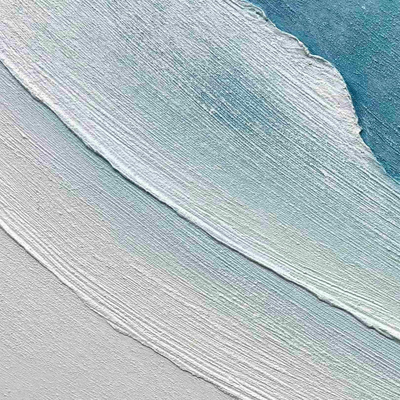 Textured minimalist beach wall art with soft blue, white, and gray tones, hand-painted with thick brushstrokes evoking ocean waves.